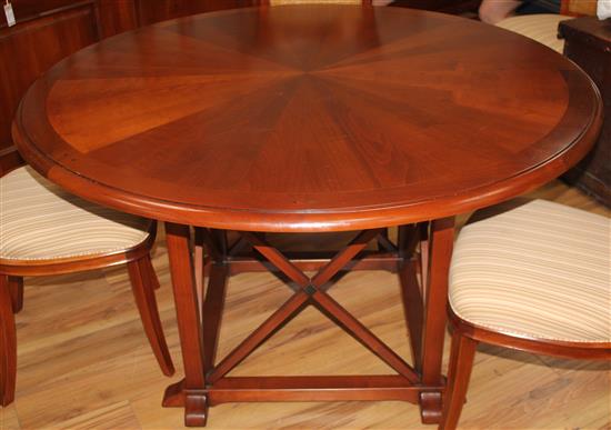 A 20th century French cherrywood radially extending dining table, the circular table extends to 6ft 7in.